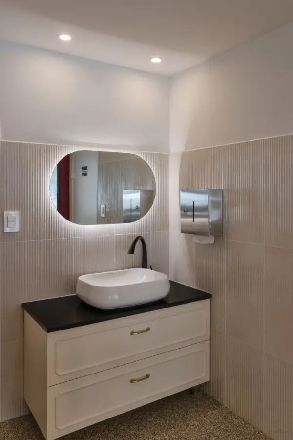 플로팅 세면대와 오벌 거울이 돋보이는 모던 화장실